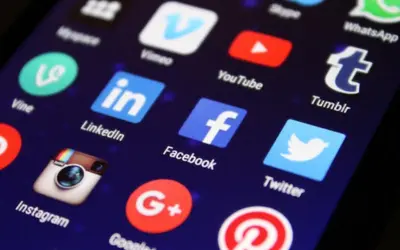 Smartphone screen displaying popular social media app icons including Facebook, Instagram, LinkedIn, Twitter, and YouTube, representing social media marketing and online engagement.
